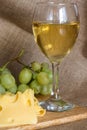 Still life with glass of white wine, cheese and grapes Royalty Free Stock Photo
