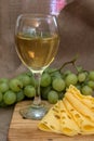 Still life with glass of white wine, cheese and grapes Royalty Free Stock Photo