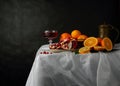 Still life with a glass of wine, jug and fruit on a dark background Royalty Free Stock Photo