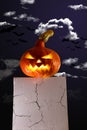 Still life with a glowing Jack\'s lantern with smoke on bedside table against the background of the night ominous sky
