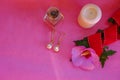 Still life with golden earrings with pearls, white candle, bottle with perfume, pink flower on pink background. Copy space. top vi Royalty Free Stock Photo