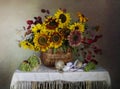 Still life with grapes and sunflowers on the table. Royalty Free Stock Photo