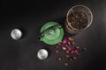 Still life with a green cast-iron teapot, two Japanese porcelain cups, a glass jar with tea and dried rosebuds Royalty Free Stock Photo