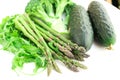 Still life from green farm vegetables, arugula, broccoli, asparagus and cucumbers on white background Royalty Free Stock Photo