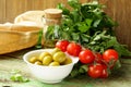 Still life of green marinated olives, herbs, tomatoes Royalty Free Stock Photo