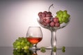 Still life with green and red grapes and wine in a bottle and a glass Royalty Free Stock Photo