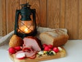 Still life with ham, homemade bread and a lantern Royalty Free Stock Photo