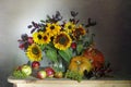 A spectacular bouquet of sunflowers in a vase and apples, grapes,pumpkins. Royalty Free Stock Photo