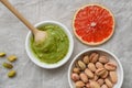 Still life of healthy food, pistachio paste, peeled and unpeeled salted pistachios, grapefruit, wooden spoon on a light background Royalty Free Stock Photo