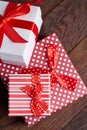 Still life with holiday gift in small red color box with ribbon and bow on wooden background, top view, close-up Royalty Free Stock Photo