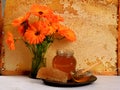 Still life with Honeycomb in a wooden frame decorated with orange autumn flower and glass jar of honey