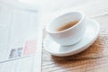 Still life image of cup of black coffee with fresh sport newspaper on the wooden table next to big coffee shop window Royalty Free Stock Photo