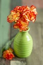 Still life image with small colorful carnations on a rustic table Royalty Free Stock Photo