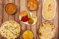 Still life of Indian food dishes with chicken and lamb curry, basmati rice, cheese naan, yellow curry, appetizer plate with fried Royalty Free Stock Photo