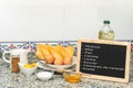 Still life with the ingredients for making french toast. Blackboard say eggs, honey, bread, cinnamon, milk, sugar, orange peels, Royalty Free Stock Photo