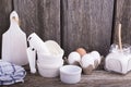 Still life on a kitchen wooden table with white ceramic molds for baking, eggs, flour and other utensils