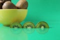 Still life kiwi fruit in a yellow bowl plate and next to a kiwi copyspace slice Royalty Free Stock Photo