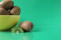 Still life kiwi fruit in a yellow bowl plate and next to a kiwi copyspace slice Royalty Free Stock Photo