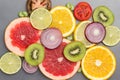 Still life of kiwi, lime and tomato fruit slices on gray Royalty Free Stock Photo