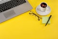 Still life with laptop, coffee and stationary elements on a yellow background Royalty Free Stock Photo