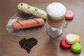 Still life with latte cup, eclairs, macaroons and coffee beans