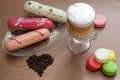 Still life with latte cup, eclairs, macaroons and coffee beans