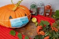 Still life, layout with a warm red scarf, oak leaves, candlesticks and rowan berries on a brown surface and pumpkin