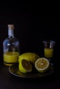 Limoncello traditional italian lemon liqueur with bottle, glass and fresh lemon halves Royalty Free Stock Photo