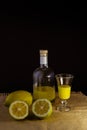 Limoncello traditional italian lemon liqueur with bottle, glass and fresh lemon halves Royalty Free Stock Photo