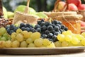 Still life with lots of fruit and a cluster of green grapes, outdoor shot Royalty Free Stock Photo