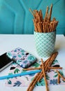 Still life made of objects - salt sticks in a mug, plys - salt sticks in a mug, plastic card box, pencil and a postcard