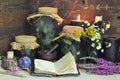 Still life with magic bottles, open witch diary, herbs and black candles on table