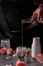 Still life of a man pouring cold sparkling water into a glass with ice. located and a black Royalty Free Stock Photo