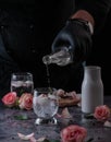 Still life of a man pouring cold sparkling water into a glass with ice. located and a black Royalty Free Stock Photo