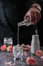 Still life of a man pouring cold sparkling water into a glass with ice. located and a black Royalty Free Stock Photo