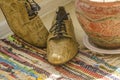 Still life with man shoes, flower pot and woven rug Royalty Free Stock Photo