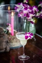 Still life with margarita cocktail, orchid flowers butning candle and hotei Royalty Free Stock Photo