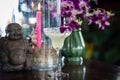 Still life with margarita cocktail, orchid flowers butning candle and hotei Royalty Free Stock Photo