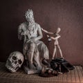 Still life of moses statue ,skull,wooden figure on mat