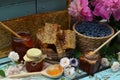 Still life with natural honey, honeycomb cut in pieces and honeysuckle berry with flowers on wooden background outside. Royalty Free Stock Photo