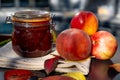 Still life with nectarines, jam and autumn leaves. Autumn harvest season. Fresh delicious healthy fruits, contain Royalty Free Stock Photo