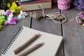 Still life of note book around nice flowers on wooden table