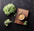 Still life with old book, coffee and dried flowers hydrangea on black vintage table top view. Flat lay styling.