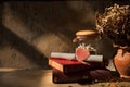 Still life with old book,shell and dried roses in clay vase Royalty Free Stock Photo