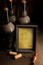 Dusty wine bottles and blank picture frame