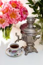Still life with old russian samovar, rustic cup of tea, bouquet with peony flowers, glasses and candles Royalty Free Stock Photo