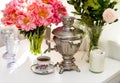 Still life with old russian samovar, rustic cup of tea, bouquet with peony flowers, glasses and candles Royalty Free Stock Photo