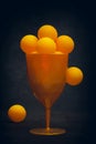 Still life with orange balls in a glass