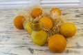 Still life with oranges, basket and glass jug with juice on old bright wooden background