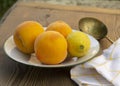 Three peaches and lemon on a wooden table Royalty Free Stock Photo